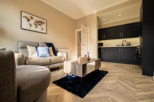 uma sala de estar com um sofá e uma mesa em Modern City Stay - SJA Stays - 2 Bed Apartment em Aberdeen