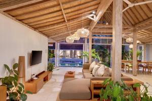 a living room with a couch and a tv at Villa Balimasan 10 mins to Canggu in Seminyak