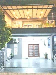 - un grand garage blanc avec une porte et un balcon dans l'établissement Arang Homestay14pax 4room(BBQ)(Kbox)Near to Beach, à Port Dickson