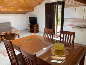a dining room with a wooden table and chairs at Apartments Hrnjić in Umag