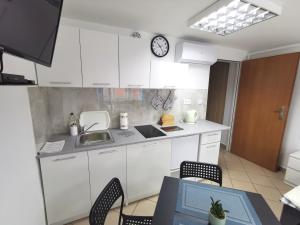 a kitchen with white cabinets and a clock on the wall at Wyspani Zator in Zator +7 photos