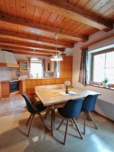 uma sala de jantar com uma mesa de madeira e cadeiras em Sonniges Landhaus in den Hohen Tauern em Rauris