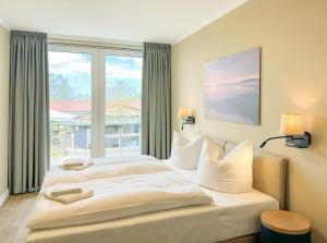 a bedroom with a large bed and a large window at Appartements "Zum Leuchtturm" Hafen Rankwitz Insel Usedom in Rankwitz