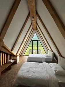 a attic bedroom with two beds and a large window at Karse in Ambrolauri
