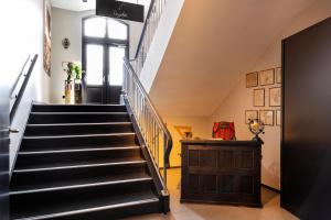 eine Treppe in einem Haus mit einer schwarzen Treppe in der Unterkunft Hotel Volksschule in Hamburg