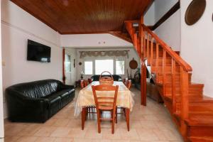 a dining room with a table and a couch at Docker 2 Beachfront Villa Vourvourou by Halkidiki Villas in Vourvourou
