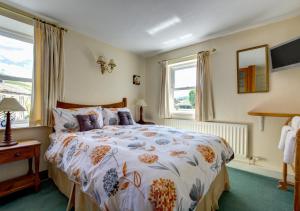 a bedroom with a large bed and a window at East Cottage in Thwaite