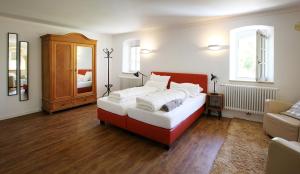een slaapkamer met een rood en wit bed en een bank bij Weingut Schäffer in Neustadt an der Weinstraße
