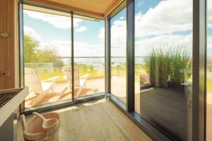 a glass house with a view of the ocean at Appartements "Zum Leuchtturm" Hafen Rankwitz Insel Usedom in Rankwitz