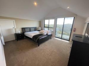 a bedroom with a bed and a large window at IceBreaker - Mount Hotham in Mount Hotham