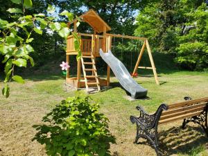 a playground with a slide and a play house at Familienfreundliche Ferienwohnung Soltau in Soltau