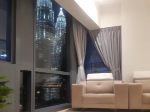 uma sala de estar com duas cadeiras em frente a uma janela em Star KLCC by Arman em Kuala Lumpur
