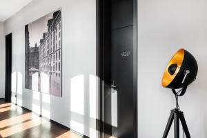 a microphone on a tripod next to a wall with paintings at Hotel Volksschule in Hamburg