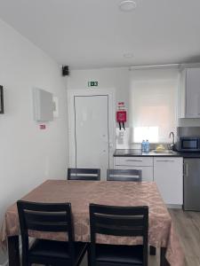 a kitchen with a table and two chairs and a kitchen with white cabinets at CASAS DONA EMILIA in Vieira de Leiria