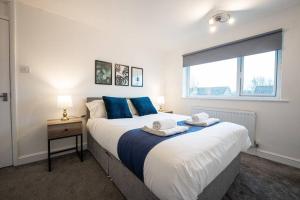 um quarto com uma cama grande e toalhas em Marykirk House 3 Double Bedrooms Workstays UK em Thornaby on Tees