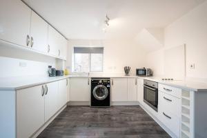 a white kitchen with a washing machine in it at Marykirk House 3 Double Bedrooms Workstays UK in Thornaby on Tees