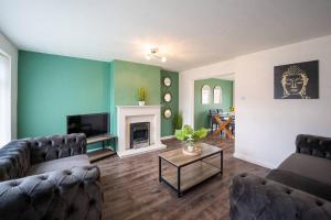 uma sala de estar com dois sofás e uma lareira em Marykirk House 3 Double Bedrooms Workstays UK em Thornaby on Tees