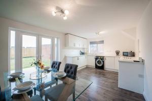 a kitchen and dining room with a glass table and chairs at Marykirk House 3 Double Bedrooms Workstays UK in Thornaby on Tees