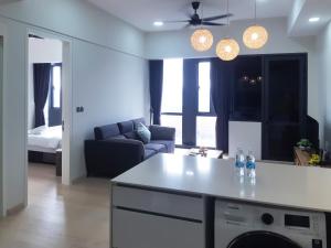 uma cozinha e sala de estar com um sofá e uma mesa em Star KLCC by Arman em Kuala Lumpur