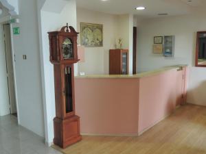 un reloj de abuelo en una habitación con un mostrador en Miami Studios, en Loutra Edipsou