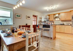 a kitchen and dining room with a wooden table and a tableablish at Drumaldrace in Hawes