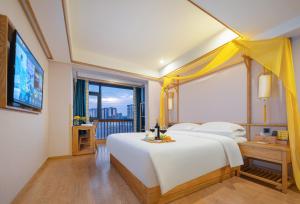 a bedroom with a large white bed and a large window at Xiangxi's Love - Yangyun Hotel in Zhangjiajie