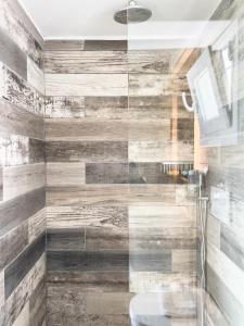 a bathroom with a shower with wooden walls at George Studios in Naxos Chora