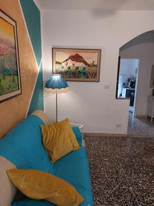 een woonkamer met een blauwe bank en een lamp bij Appartamento La Fortezza in Livorno