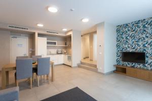 a kitchen and dining room with a table and a tv at Mosella Suite Hotel in Sottomarina