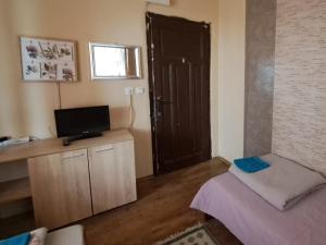 a living room with a door and a tv and a room at Guest House The House in Plovdiv