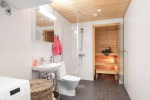 a bathroom with a toilet and a sink and a shower at Huoneisto järvinäkymin, Palokka in Jyväskylä