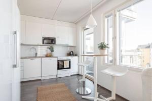 a kitchen with white cabinets and a table and chairs at Huoneisto järvinäkymin, Palokka in Jyväskylä