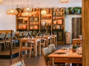 a restaurant with wooden tables and chairs and shelves at ibis Styles Avignon Sud in Avignon