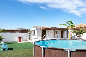 einen Hinterhof mit einem Pool und einem Haus in der Unterkunft Villa Triana in Chiclana de la Frontera