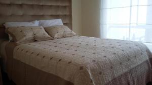 1 dormitorio con 1 cama con edredón blanco y ventana en San Martin Apartment Miraflores, en Lima