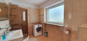 a bathroom with a washing machine next to a window at Apartments in Villa Barbara in Świeradów-Zdrój +115 photos