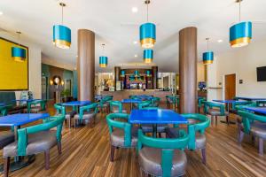 a restaurant with blue tables and chairs at Best Western Plus Miami Executive Airport Hotel and Suites in Kendall