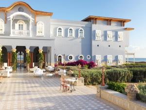 een groot wit gebouw met een patio ervoor bij La Maison Bleue El Gouna in Hurghada
