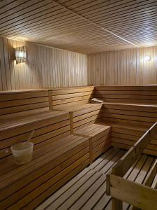 an empty wooden sauna with a bucket in it at Grand Nur Plaza Hotel in Aktau