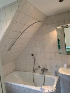 a bath tub with a shower in a bathroom at Ferienwohnung 2 in Huglfing im Herzen vom 5 Seen Land Oberbayern in Huglfing