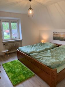 a bedroom with a bed with green sheets and a green rug at Ferienwohnung 2 in Huglfing im Herzen vom 5 Seen Land Oberbayern in Huglfing +10 photos