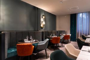un restaurante con mesas y sillas en una habitación en Quark Hotel Milano en Milán