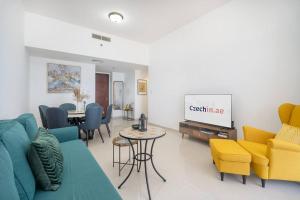 a living room with a couch and chairs and a tv at Relax in Spacious 2BD with Sea View in Al Hamra in Ras al Khaimah