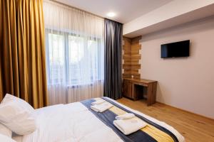 a bedroom with a bed and a tv and a window at Dream Hotel in Haghpat