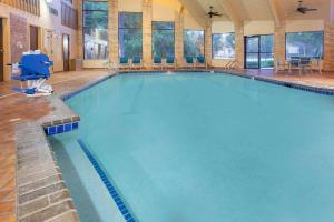 a large indoor swimming pool with blue water at AmericInn by Wyndham Delafield in Delafield