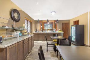 a kitchen with tables and chairs and a clock on the wall at AmericInn by Wyndham Delafield in Delafield