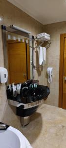 y baño con lavabo y bañera negra. en Grand Nur Plaza Hotel, en Aktau