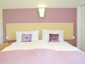 a bedroom with a large bed with two purple pillows at Dove Meadow in Denstone