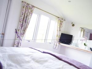 a bedroom with a bed and a window at Dove Meadow in Denstone