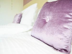 almohada morada sobre una cama en Dove Meadow, en Denstone